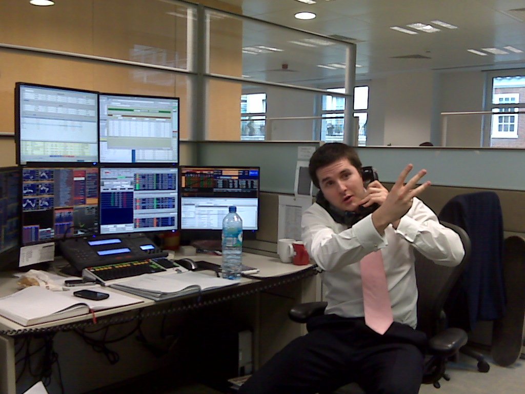 Operador bursátil revisando cotizaciones de mercado en pantalla, ilustrando el seguimiento de posiciones antes del vencimiento de un contrato