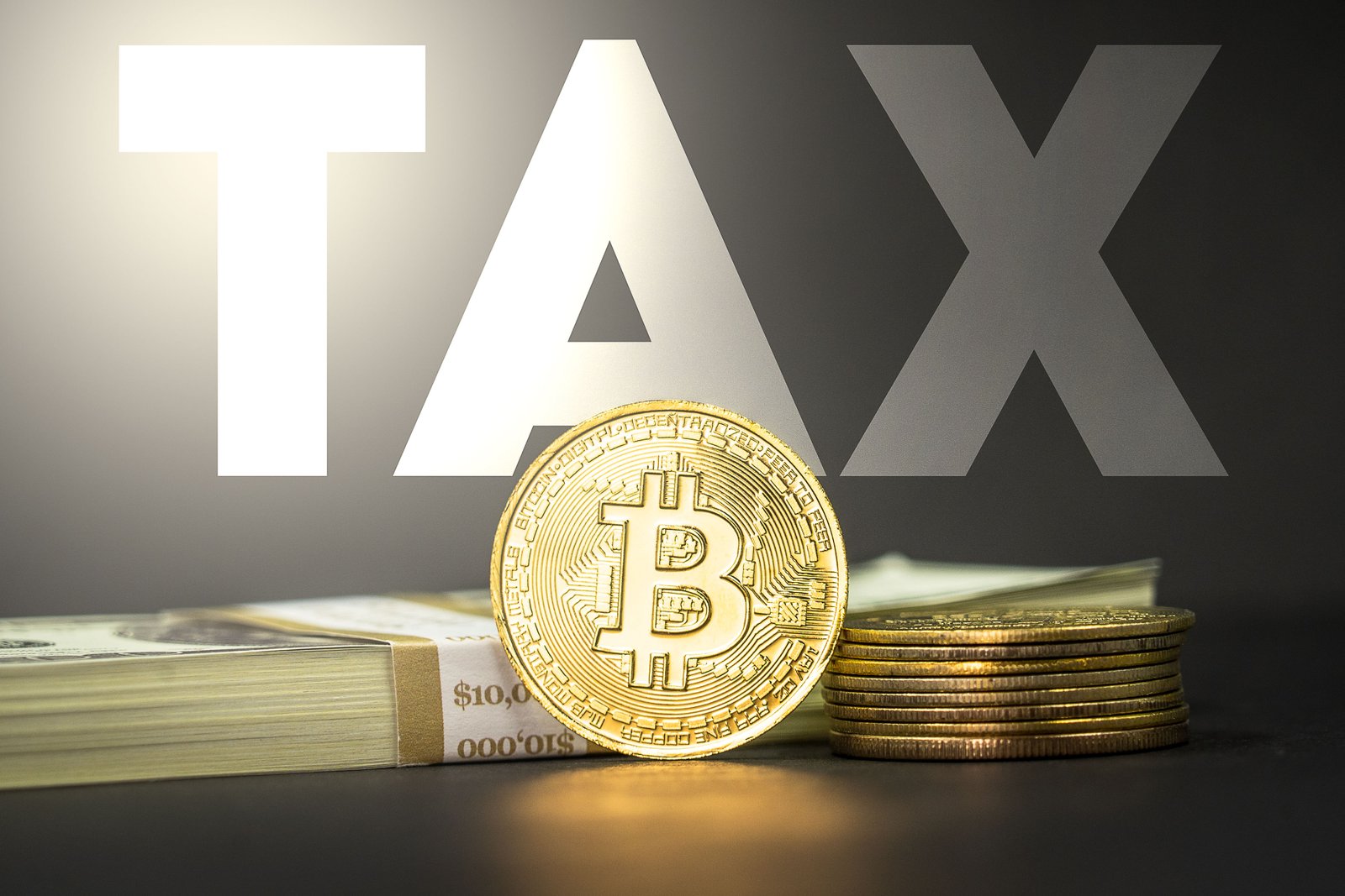 Medallón con el símbolo de Bitcoin junto a la palabra 'Tax', representando los impuestos sobre criptomonedas